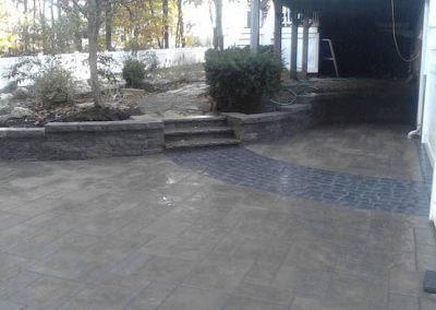 photo of a paver driveway and retaining wall built by Ideal Landscape of Holden MA